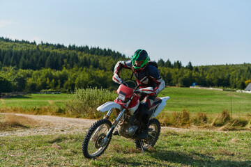 Fototapeta na wymiar A professional motocross rider starting their motorcycle, poised to begin a high-adrenaline training session on a hazardous forest trail, embodying the spirit of off-road adventure