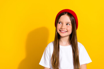 Photo portrait of charming schoolgirl look interested empty space dressed stylish white garment isolated on yellow color background