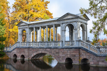 Fototapeta na wymiar Marble bridge and autumn foliage in Catherine park, Tsarskoe Selo (Pushkin), Saint Petersburg, Russia
