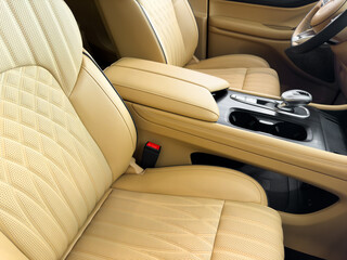 Modern luxury car brown leather interior. Part of orange leather car seat details with white...