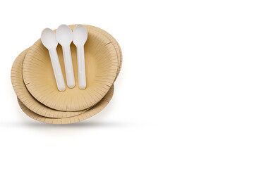 Brown disposable round paper plates and paper teaspoon isolated on white background. Plastic free...