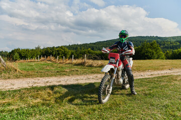 Fototapeta premium A motorcyclist equipped with professional gear, rides motocross on perilous meadows, training for an upcoming competition.