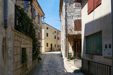 Narrow street between old houses in Motovun on a sunny day