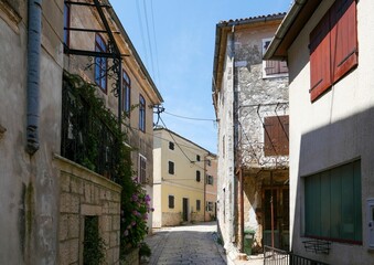 Narrow street between old houses in Motovun on a sunny day