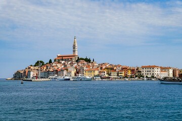 Fototapeta na wymiar View of Rovinj fishing port with colorful architecture and small ships floating on water, Croatia