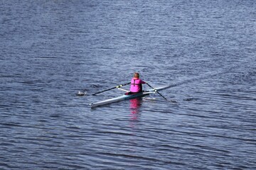 Person on a boat of sup sport rowing in the middle of water