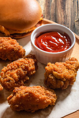 Chicken fried breaded with ketchup on a wooden tray