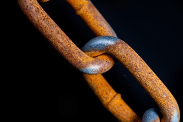 Closeup of rusty metal chain link on black background