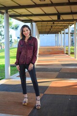 White young woman wearing a casual outfit posing for the camera at the cafe, vertical