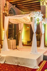 several white chairs near a white structure with white draping