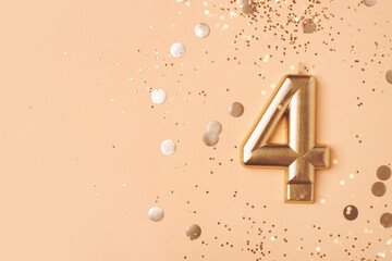 Gold candle in the form of number four.
