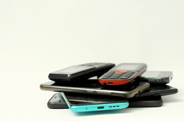 old mobile phones piled up on a table with white background no people stock photo
