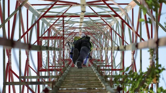 Technician climbing a network tower to fix it. Skilled work that technicians do to keep our communication networks running smoothly