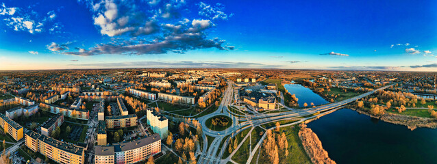 Aerial shot of the urban city near a lake against a blue sky