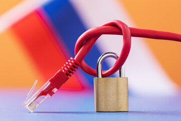 Closed padlock on a knotted network wire on the background of the Russian flag, the concept of...