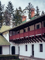 two white houses with green roof tops with two chimneys and a bell tower