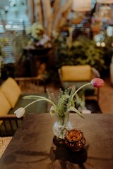 a table with a vase of tulips and other items