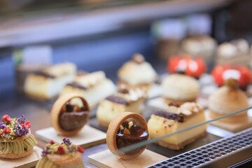 Selection of delicious pastries and desserts, arranged on dessert fridge display