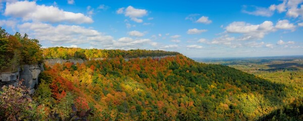 Panoramic scene of green mountains and trees in Thacher State Park in New York with blue sky