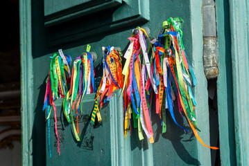 View of the entrance door of the Senhor do Bonfim church with colorful souvenir ribbons hanging. City of Salvador, Bahia.