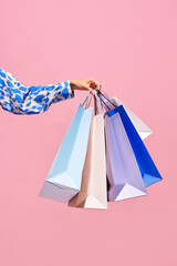 Sale offer. Black Friday. Shopping discount. Closeup of woman hand holding purchase blue bags...