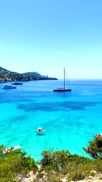 Vertical landscape scene of boats by the coast of Malaguf beach Majorca, Spain