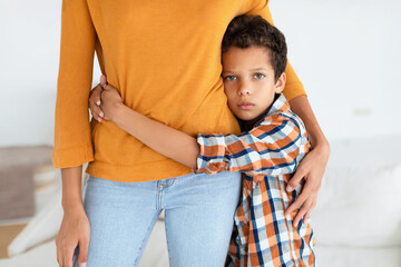 Sad Son Hugging Mother Looking At Camera At Home, Cropped