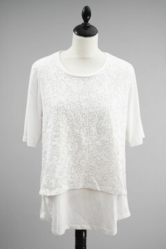 A beautiful white blouse top with lace hangs on a headless mannequin against a light gray background