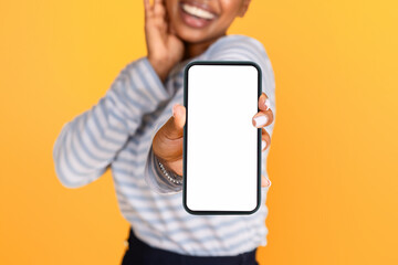 Unrecognizable black woman showing smartphone with white blank screen