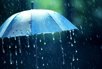 Fotobehang Umbrella under rainfall.Blue umbrella in the rain. Rainy day in rainy season.Rainy weather concept. © Emmy Ljs