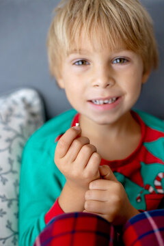 Sweet blond preschool child, boy, loosing his first milk tooth, smiling happily, holding the little tooth