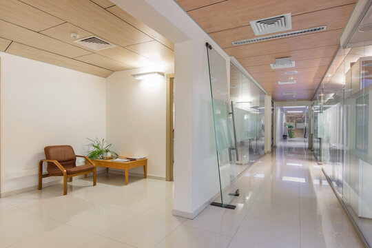 A room in an office with light walls and a floor with an armchair and a small table.