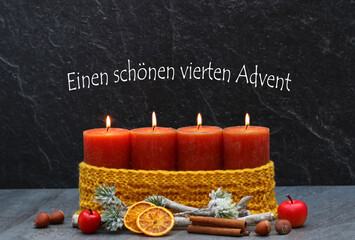 Vierter Advent: Vier brennenden Kerze mit Weihnachtsdekoration vor dunkelm Hintergrund. Mit dem...