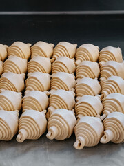 Raw croissants in production in a bakery close-up