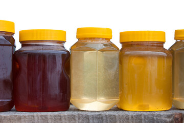 Jars with yellow plastic lids with different types of honey - buckwheat, linden, flower