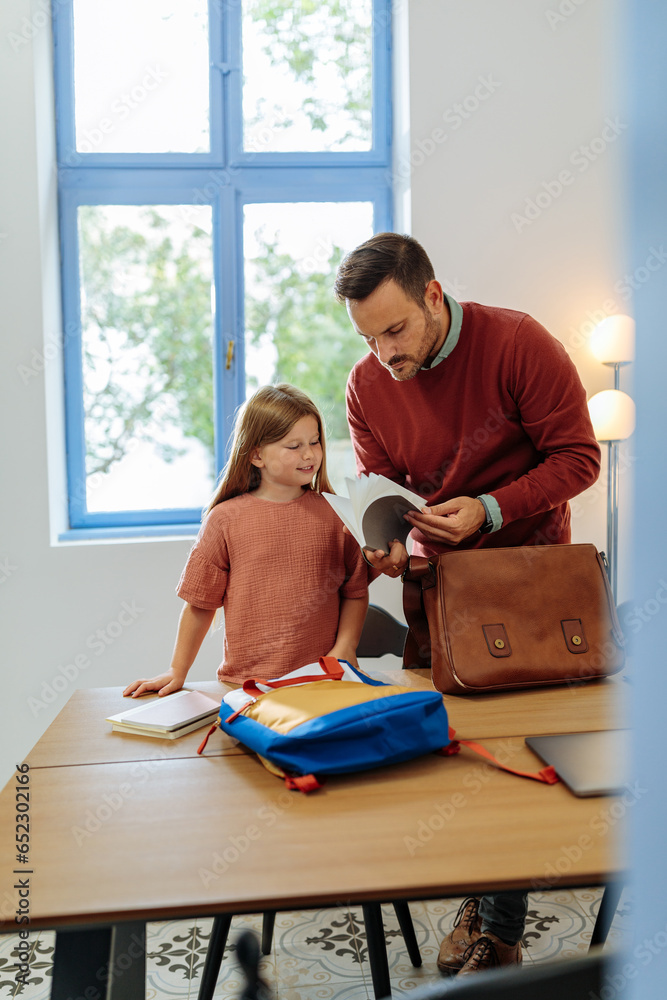 Wall mural father and daughter checking her school books