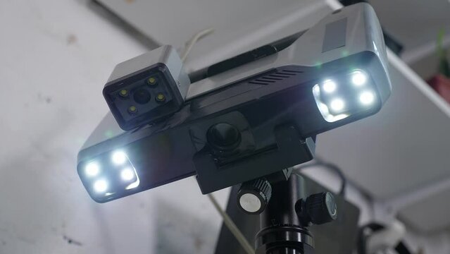 Close-up of a working modern 3D scanner reading data from a plastic object. A 3D scanner scans a plastic model in a modern laboratory. The process of creating 3D models.