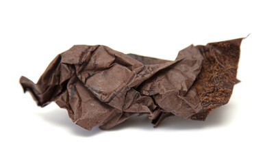 square piece of old crumpled chocolate-colored paper on a white background
