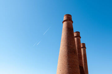 Paisaje industrial con tres antiguas chimeneas de ladrillo de una industria.