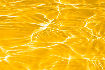 Defocus blurred transparent orange colored clear calm water surface texture with splashes...