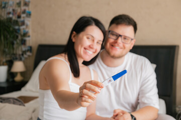 happy couple looking at positive pregnancy test