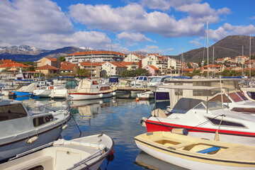 Fototapeta na wymiar Beautiful Mediterranean landscape on sunny winter day. Fishing boats in harbor. Montenegro, Tivat city. View of Marina Kalimanj