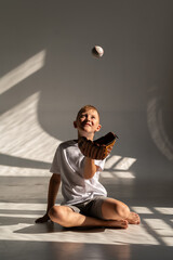Boy playing with baseball and glove on white background. Throws and catches the ball