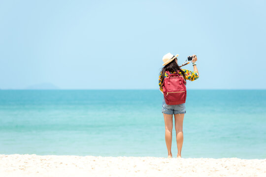 Happy traveler and tourism young women travel summer on the beach.  Asian  people holding map and camera take photo  and relax outdoor for destination and leisure trip travel in holiday