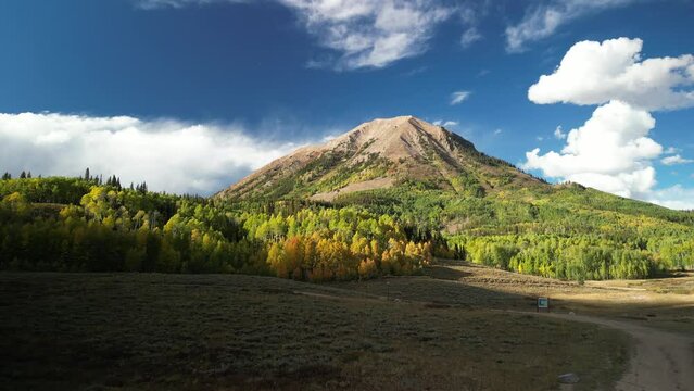 Aerial of Gothic Mountain in Crested Butte Colorado with yellow aspens and blue sky in fall