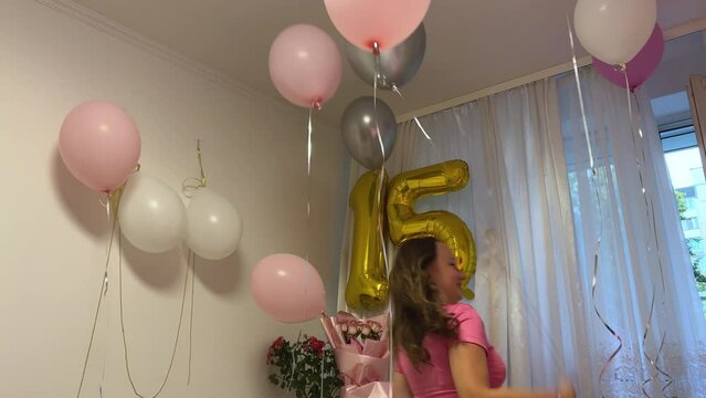 celebrate 15th birthday, teenager girl runs around the room pulling helium balloons