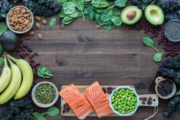 Various foods high in magnesium forming a border on a wooden table. 