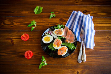 boiled eggs with salted red fish, herbs and seasonings in a plate .