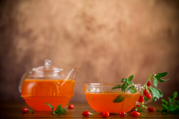 Prepared drink from ripe goji berries in a glass cup and teapot