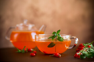 Prepared drink from ripe goji berries in a glass cup and teapot